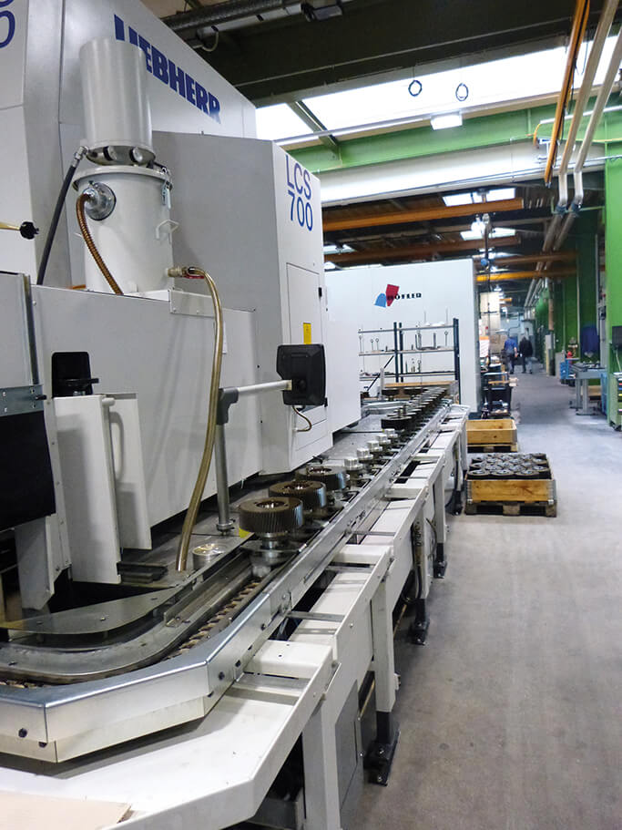 Palet konveyöründe iş parçaları bulunan otomatik Liebherr LCS 700 makinesi.